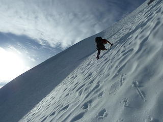 Sergio kicks steps up the steep headwall below the summit.