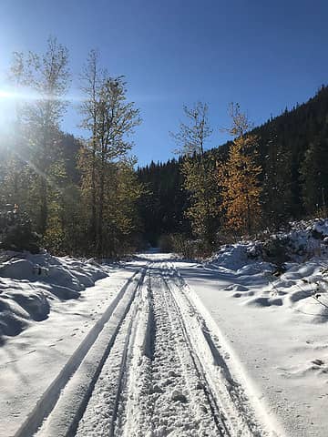 Following snowmobile tracks through a mix of fall and winter