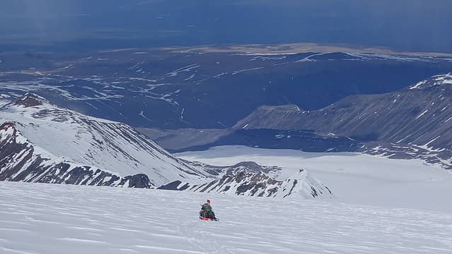 Laura sledding with the lower glacier visible