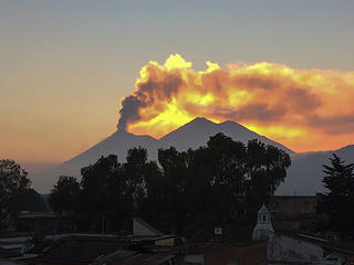 Volcan Fuego erupting with the sun setting behind the ash cloud