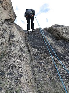 Kathleen rappelling at top of the crux