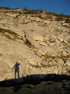 Evening shadow walking past blocky granite hillsides