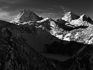 Corteo Peak and Black Peak rise above frozen Lake Ann in North Cascades National Park.