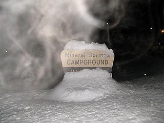 Trailhead sign, with steaming breath lit up by the flash