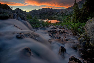 A creek filled by snowmelt cascades toward Island Lake in the Wind River Range as the sun sets.