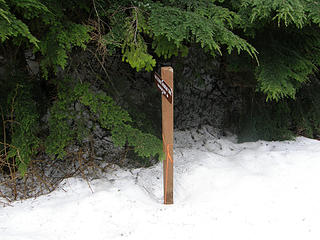 Rattlesnake Mountain trail misleading pointing sign. This sign points up towareds a minor summit with a small tower.