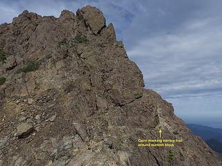 Cairn marks narrow trail that circumnavigates summit block towards summit ridge