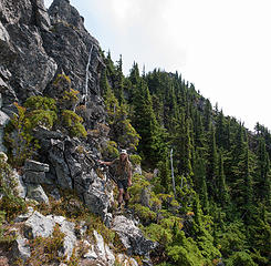 Returning along the rocky ledge around the cat tower just below the summit