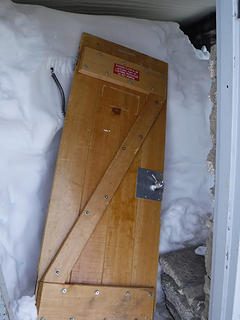 Broken door and snow filled shelter